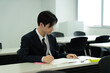 © Paylessimages - 教室で勉強している制服の10代の少年
