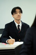 © Paylessimages - 教室で勉強している制服の10代の少年