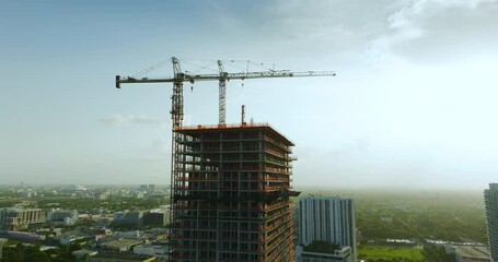 Wall Mural - Aerial view of new developing residence in American urban area. Tower cranes at industrial construction site in Miami, Florida. Concept of housing growth in the USA