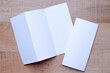 Blank trifold brochure A4 booklet on wooden background with clipping path. Folded and unfolded.