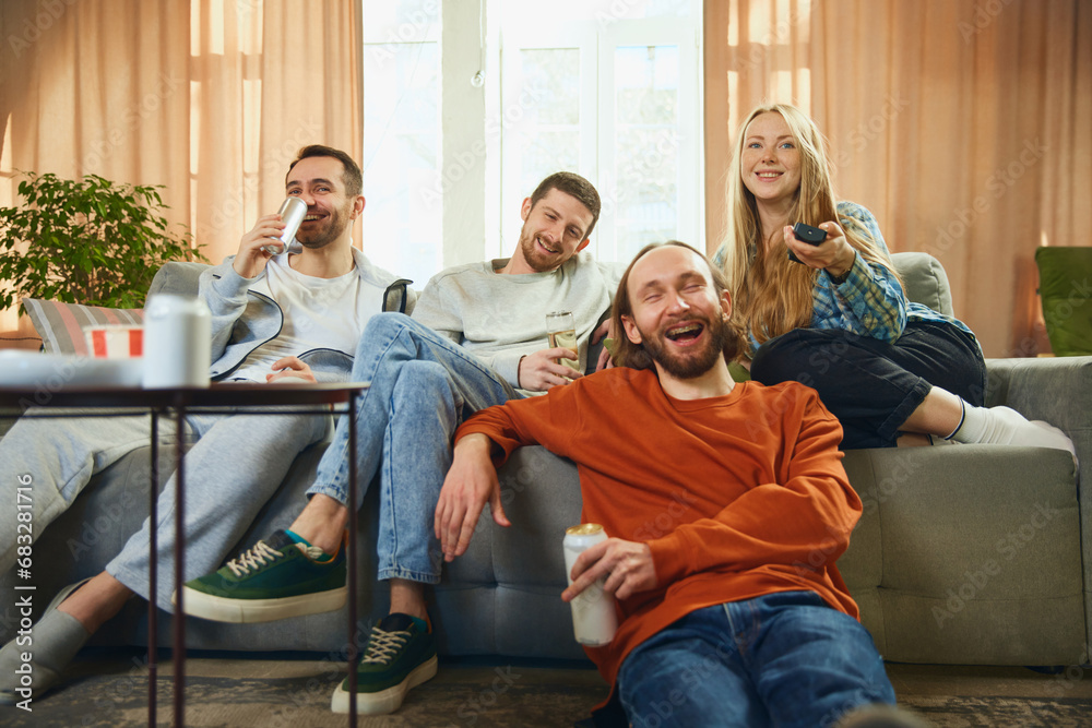 Angle view of a happy group of friends sitting on the sofa in the ...