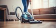 woman cleaning floor with vacuum cleaner