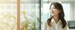 © yj - Happy confident Korean business woman leader looking away standing in office. Smiling professional Korea manager executive, East Asian female worker thinking of financial success. generative AI