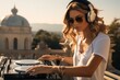 Girl dj plays music outdoors on the terrace of a mansion.