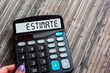 A woman's hand holds a calculator with the word ESTIMATE. cost calculation or estimation concept