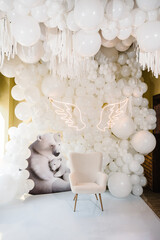 Wall Mural - Arch decorated white balloons, angel wings, bears and chair for baptism. Photo area decoration space with white background. Trendy decor. Celebration concept. Reception at birthday baby party on wall.