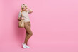© deagreez - Full body photo of stunning cheerful lady hold bag arm touch hair empty space ad isolated on pink color background