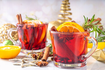 Wall Mural - Traditional Christmas aromatic mulled wine cocktail, red wine grog tea drink with spices, cinnamon, orange and rosemary sprig, on Christmas New Year decorated wooden cozy background