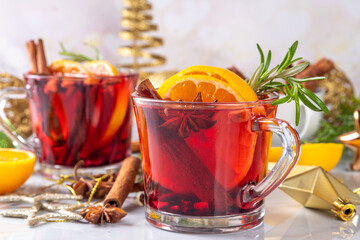 Wall Mural - Traditional Christmas aromatic mulled wine cocktail, red wine grog tea drink with spices, cinnamon, orange and rosemary sprig, on Christmas New Year decorated wooden cozy background