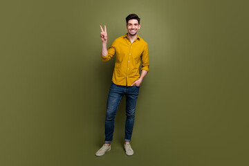 Poster - Full length photo of cheerful positive nice man wear trendy clothes showing hand v-sign isolated on khaki color background