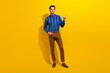 Full body photo of handsome man wear bow tie stylish shirt indicating at proposition empty space isolated on yellow color background