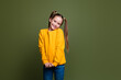 © deagreez - Portrait of cute adorable positive small kid with tails hairstyle dressed yellow sweatshirt smiling isolated on khaki color background