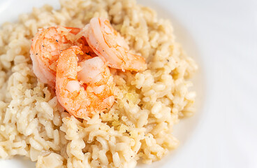 Poster - Close up view of creamy homemade traditional italian risotto dish made of fried and boiled arborio rice cooked with broth decorated with shrimps or prawns seafood and parmesan cheese served in plate