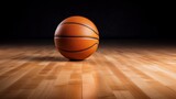 Fototapeta Sport -  an orange basketball sitting on top of a hard wood floor in a dark room with a spotlight on the floor.