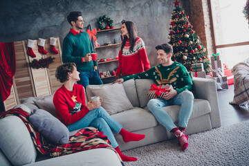 Canvas Print - Full length portrait of peaceful friendly people sitting couch enjoy hot cacao mug speak fairy new year time apartment indoors