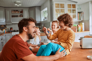 Cheerful family has fun during a meal at the dining table