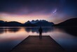 a man standing lonely in front of a big lake with an atmospheric and breathetaking sky - for those, who wander alone and for inspiration related topics