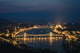 Fototapeta Most - a long bridge across the water next to a mountain near the city: Hungary, Budapest