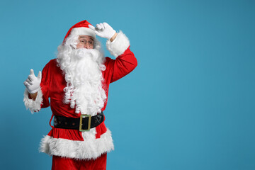 Canvas Print - Merry Christmas. Santa Claus posing on light blue background, space for text