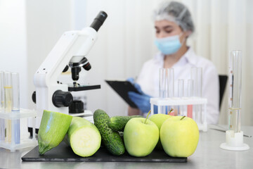 Wall Mural - fresh vegetables, fruits on table and scientist proceeding quality control in laboratory
