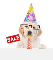 Aufkleber - Smart Golden retriever puppy wearing eyeglasses and party cap looks above empty white banner blows in party horn and shows signboard with labeled 