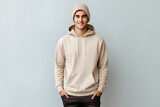 Fototapeta  - Male young model in beige blank hoodie on gray background. Clothes mockup. AI Generative