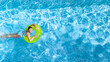 Active young girl in swimming pool aerial top view from above, teenager relaxes and swims on inflatable ring donut and has fun in water on family vacation, tropical holiday resort
