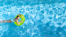 Active Young Girl In Swimming Pool Aerial Top View From Above, Teenager Relaxes And Swims On Inflatable Ring Donut And Has Fun In Water On Family Vacation, Tropical Holiday Resort
