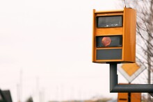 A Yellow Speed Camera Flashes As It Detects A Speeding Car On A Highway, Using Radar And Artificial Intelligence To Recognize The Number Plate And Issue A Fine.