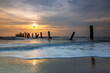 © isarescheewin - Silhouette view of the concrete columns of the old port with Beautiful sky sunrise and strong water waves on Sao Iang Beach at Phetchaburi province. Long exposure picture