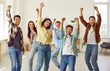 © Studio Romantic - Portrait of a group of excited happy young friends students or colleagues having fun hanging together at home. Men and women standing with raising hands up enjoying meeting and having a party.