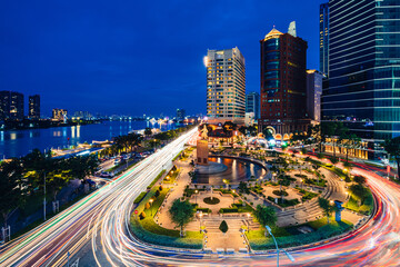 Wall Mural - View of Me Linh roundabout with heavy traffic near Bach Dang waterbus station port and Saigon river at blue hour