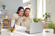 © Studio Romantic - Young family couple using their laptop computer and paying their bills online. Happy, positive man and woman looking at a paid bill and tax receipt or an email with good news like a loan approval