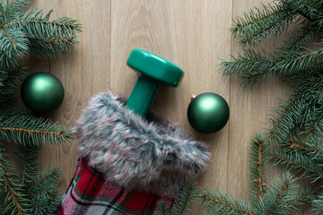 Wall Mural - Green dumbbell in a Christmas stocking, present under the tree. Exercise equipment as a gift guide idea. Healthy fitness lifestyle winter holiday season. Gym workout and sports training composition.