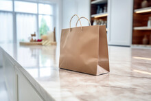 Close Up Of Empty Brown Paper Shopping Bag On White Marble Countertop In Kitchen. Shopping Concept Of Echo And Lifestyle.