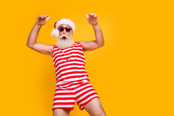 Wall Mural - Photo of cool cheerful elderly guy wear new year swimsuit hat sunglass enjoying disco empty space isolated yellow color background