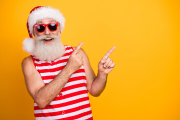 Wall Mural - Photo of cheerful excited elderly guy wear new year swimsuit hat sunglass showing two fingers empty space isolated yellow color background