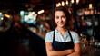 portrait of a smiling brunette woman in a dark apron against the background of a bar
