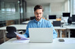© insta_photos - Busy latin young businessman checking document using computer in office. Young professional business man hr manager working on laptop doing paperwork holding corporate file cv at workplace.