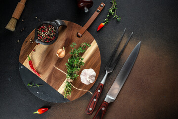 Wall Mural - Cooking table with herbs, spices and utensils on a dark background. top view. copy space for text