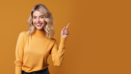 Wall Mural - Happy blonde woman pointing her finger at copy space for promotion