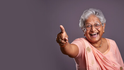 Wall Mural - Happy senior indian woman point her finger at copy space for promotion