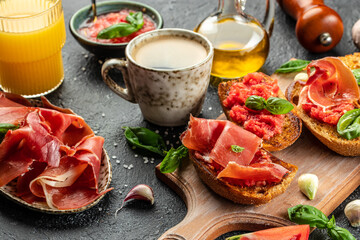 Wall Mural - Spanish breakfast with toasted bread with oil, jamon and tomato, coffee and orange juice. place for text, top view