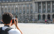 photographer with digital camera taking photographs at ancient building