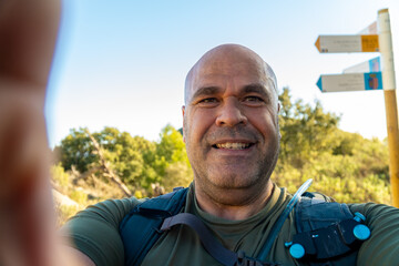 Wall Mural - Smiling hiker takes a selfie outdoors