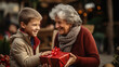 grandson gives a gift to his grandmother, a little boy congratulates an elderly woman on Christmas, New Year, Elderly Day, child, kid, son, happy face, emotions, joy, holiday, present, box, lady