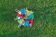 © New Africa - Group of children with teachers holding hands together on rainbow playground parachute in park, top view. Summer camp activity
