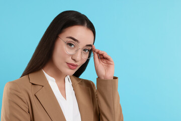 Poster - Beautiful woman wearing glasses on turquoise background, space for text