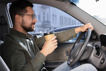 Canvas Print - Coffee to go. Handsome man with paper cup of drink driving his car