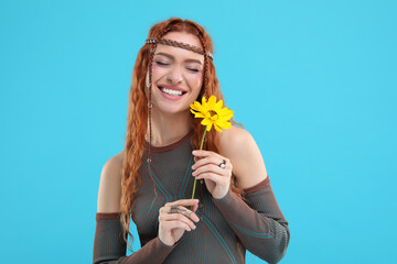 Poster - Beautiful young hippie woman with sunflower on light blue background